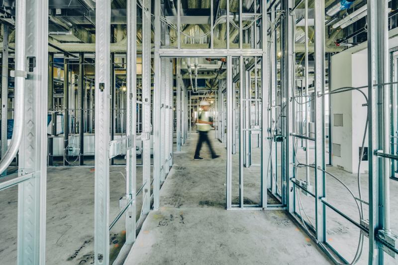 Interior construction with a person walking in the background