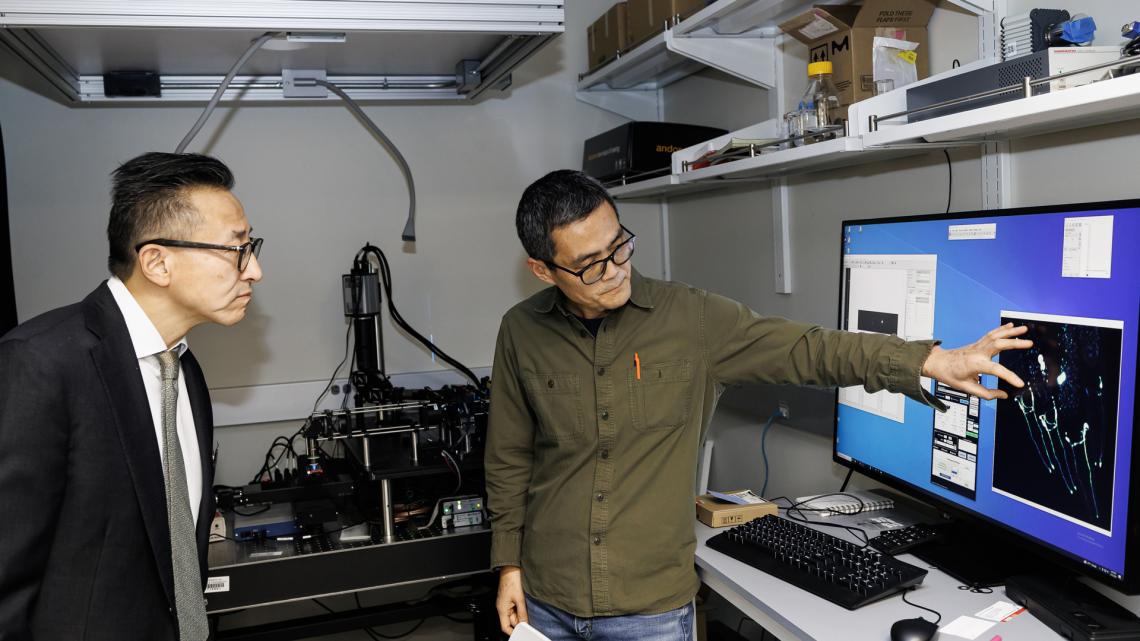 Lin Shao, Director of Microscopy at the Center, giving a demonstration to Joe Tsai. Photo by Tony Fiorini.