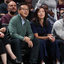 Joe Tsai and Clara Wu Tsai sitting courtside at a basketball game