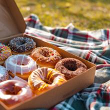 donut-box-open-with-a-variety-of-donuts-on-a-picnic-blanket