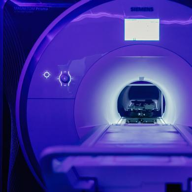 fMRI machine illuminated by purple lighting.